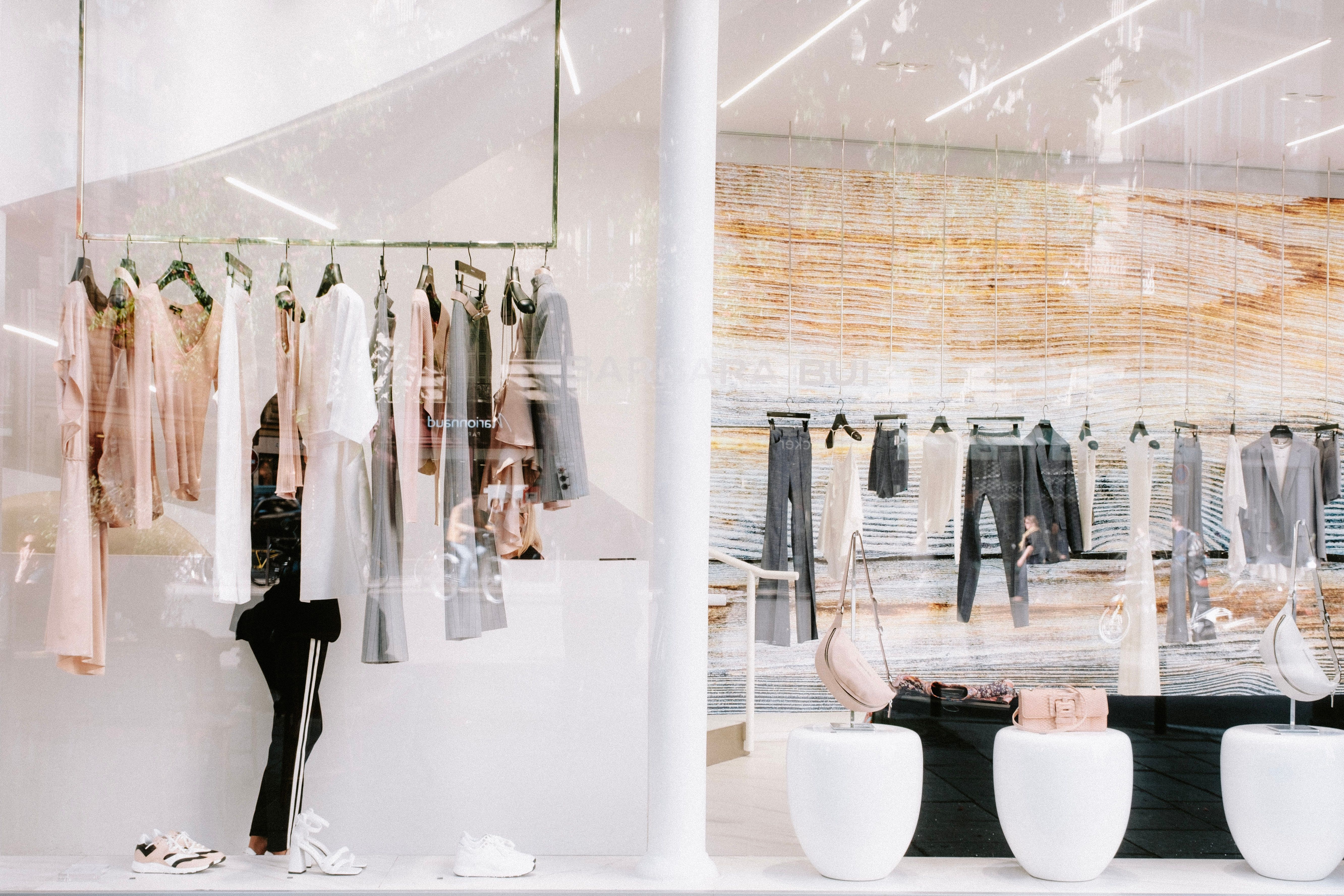 Curated fashion display in a refined boutique with restrained styling and soft reflections.