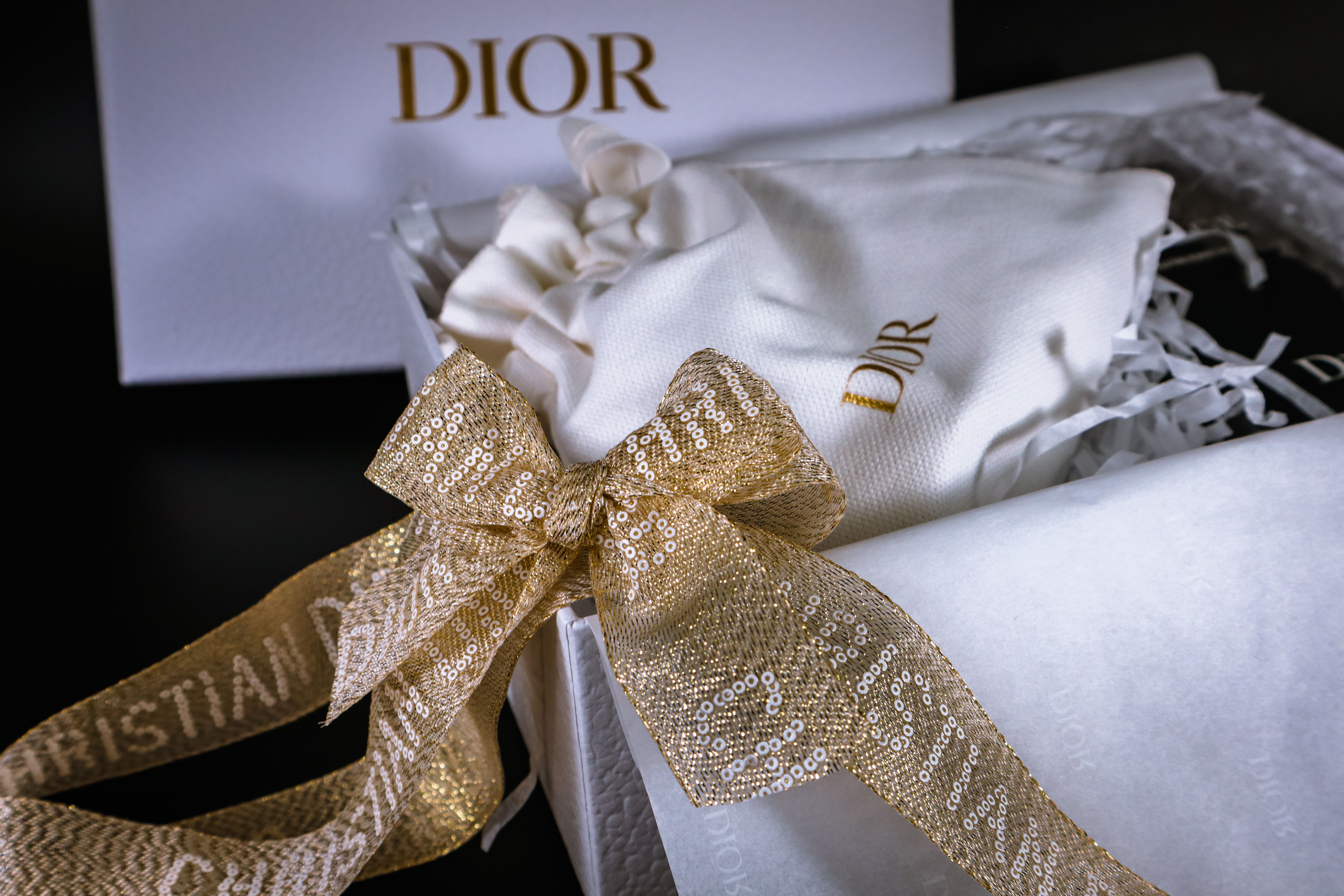 Elegant luxury gift box with a gold ribbon, representing restrained premium packaging and thoughtful service.